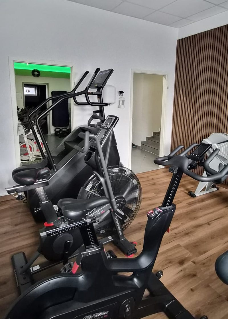 Cardio-Bereich mit Bikes und Holzakzentwand